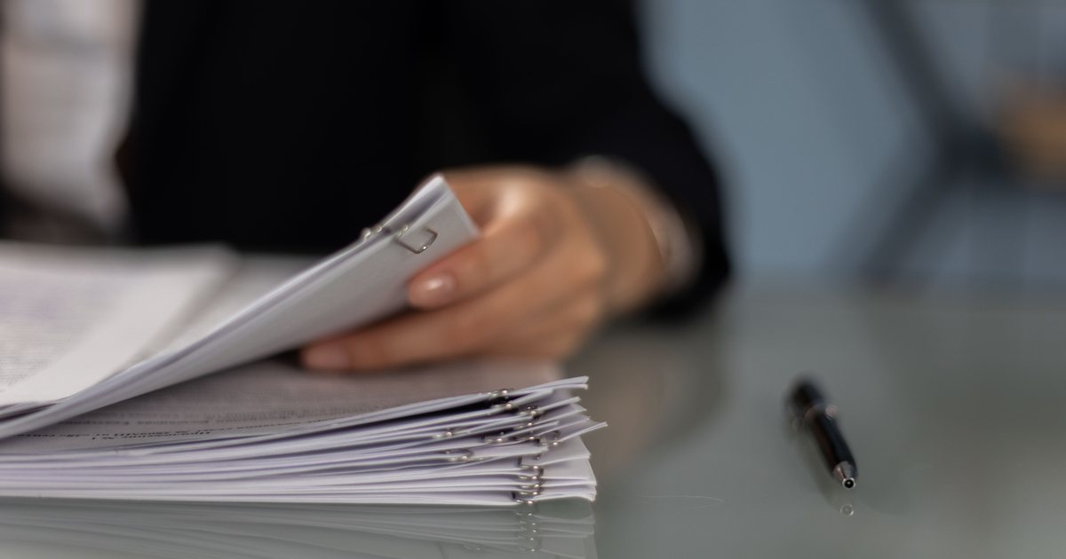 Professional reviewing a stack of documents for French certified translation